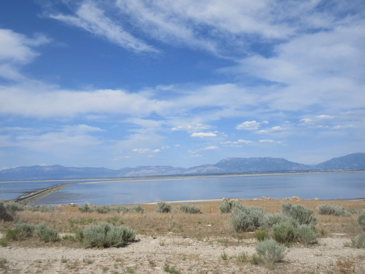 Sagebrush flats and the shoreline of Great Salt Lake on Antelope Island under a blue sky with white clouds